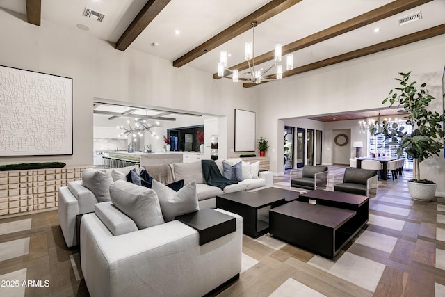 living area featuring visible vents, a high ceiling, an inviting chandelier, and beamed ceiling