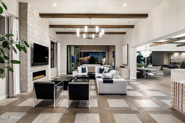 living room with beam ceiling, baseboards, a stone fireplace, and a chandelier