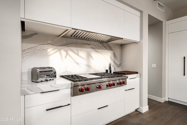 kitchen featuring visible vents, dark wood-type flooring, baseboards, stainless steel gas cooktop, and white cabinets