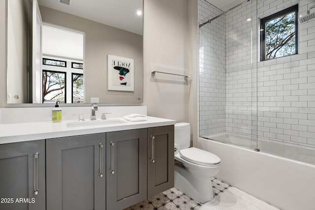 bathroom featuring a wealth of natural light, tub / shower combination, toilet, and vanity