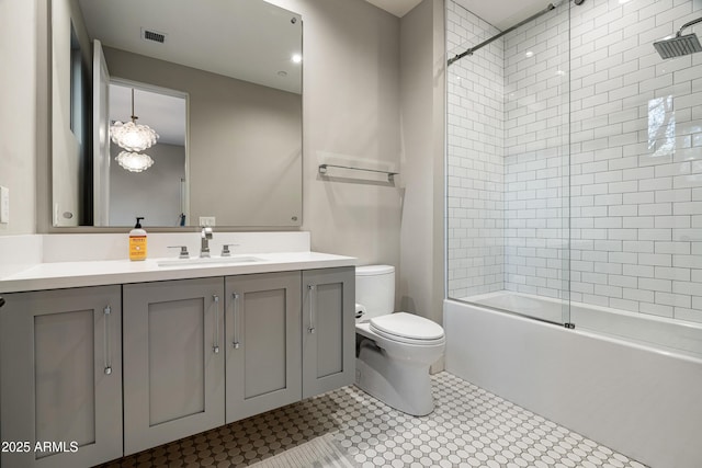 full bath with vanity, toilet, visible vents, and combined bath / shower with glass door