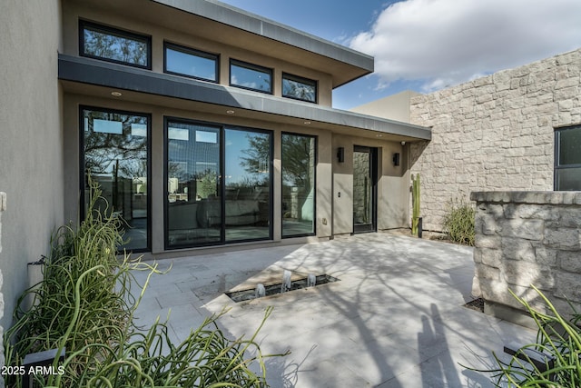 doorway to property with a patio area and stucco siding