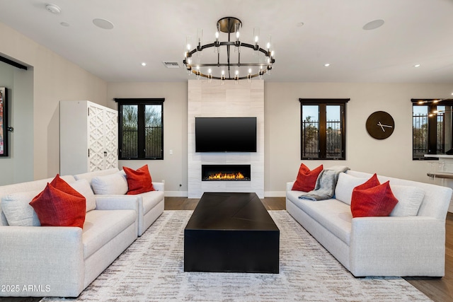 living area with visible vents, a tiled fireplace, wood finished floors, recessed lighting, and baseboards