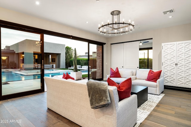 living area with recessed lighting, a notable chandelier, wood finished floors, and visible vents