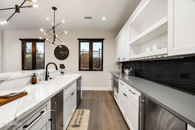 kitchen featuring visible vents, a sink, open shelves, tasteful backsplash, and dark wood-style floors