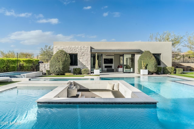 pool with a patio, an in ground hot tub, and fence