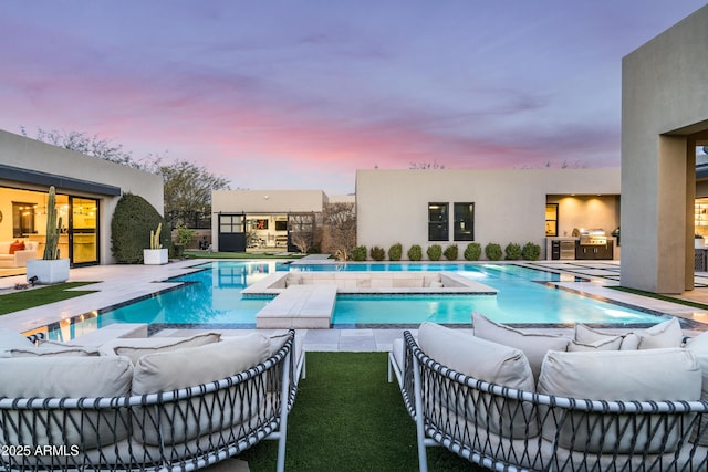 pool featuring an outdoor kitchen, an outdoor hangout area, and a patio