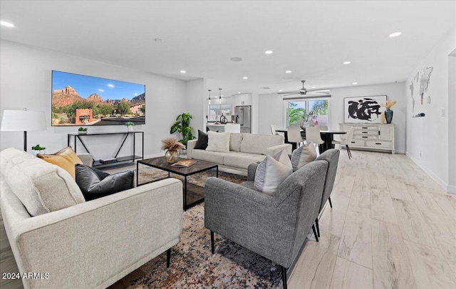 living room with light hardwood / wood-style floors and ceiling fan