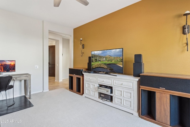 living area with light colored carpet, baseboards, and ceiling fan