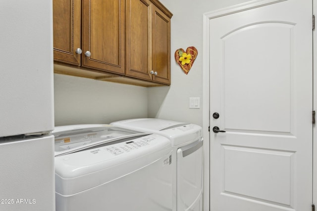 laundry area featuring washer and clothes dryer and cabinet space