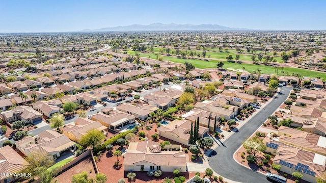 drone / aerial view with a mountain view, golf course view, and a residential view