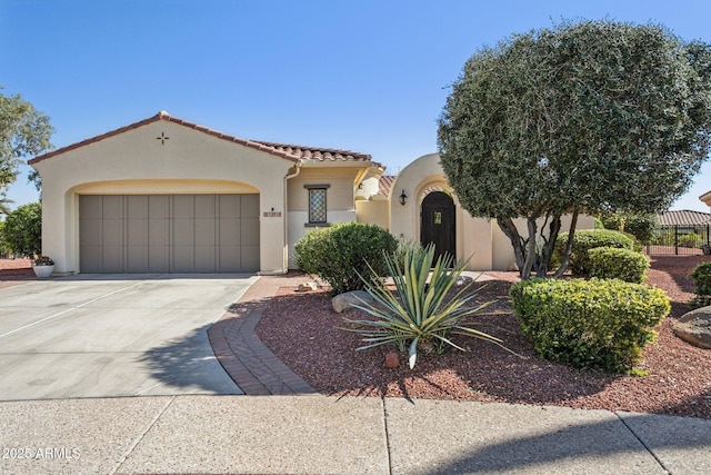 mediterranean / spanish-style house featuring a tile roof, an attached garage, driveway, and stucco siding