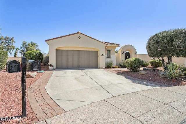 mediterranean / spanish-style house with concrete driveway, a tiled roof, an attached garage, and stucco siding