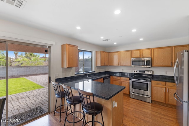 kitchen with visible vents, a sink, appliances with stainless steel finishes, a peninsula, and recessed lighting