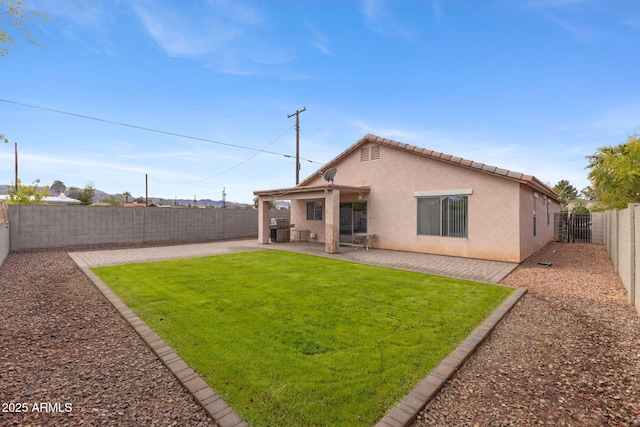 rear view of house with a patio area, a fenced backyard, a yard, and stucco siding