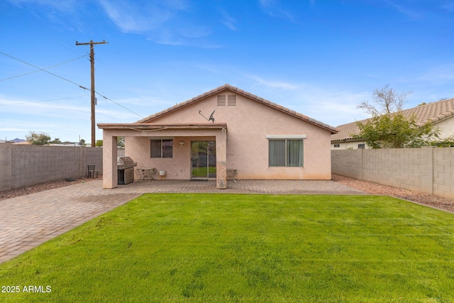 rear view of property with a patio area, a fenced backyard, a lawn, and stucco siding