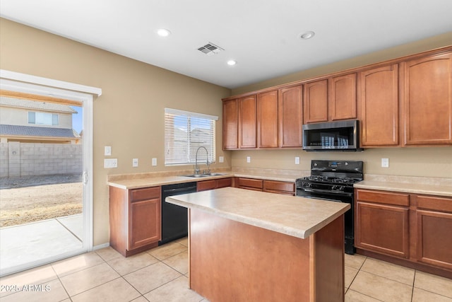 kitchen with sink, light tile patterned floors, black appliances, and a kitchen island