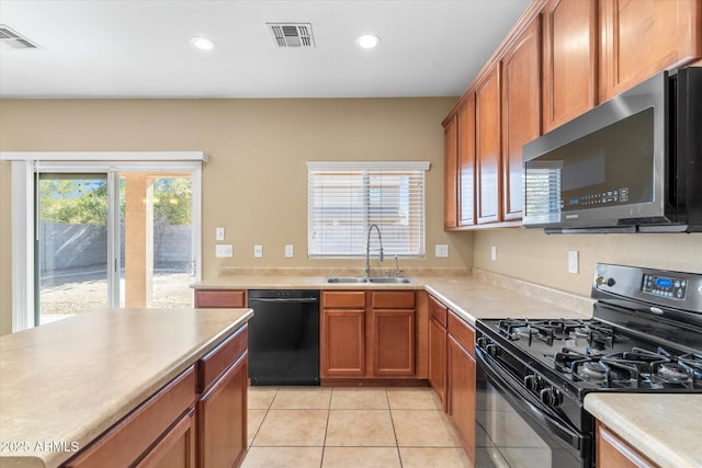 kitchen with sink, black appliances, and light tile patterned flooring