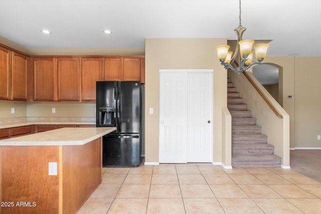 kitchen with a kitchen island, pendant lighting, light tile patterned floors, a notable chandelier, and black refrigerator with ice dispenser