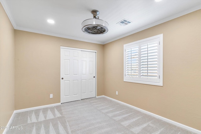 unfurnished bedroom with light colored carpet, ornamental molding, and a closet