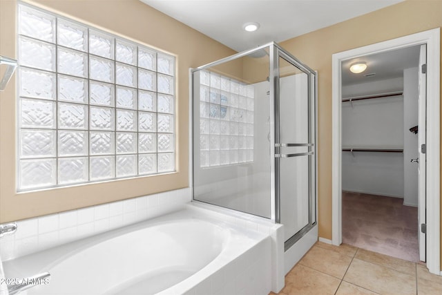 bathroom with independent shower and bath and tile patterned flooring