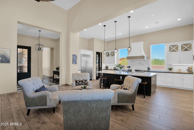 29067 N 71st Ave, Peoria, AZ 85383 - living room featuring light wood-type flooring, a towering ceiling, and recessed lighting