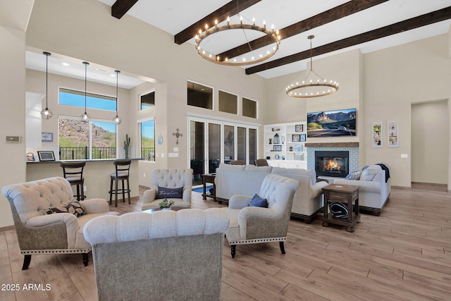 29067 N 71st Ave, Peoria, AZ 85383 - living room featuring a high ceiling, a chandelier, light wood-style floors, beamed ceiling, and a glass covered fireplace