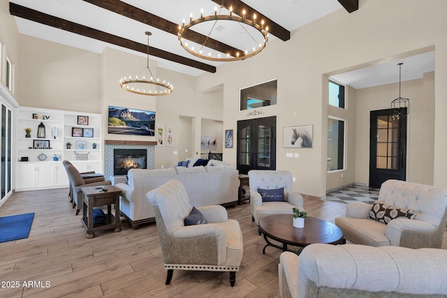29067 N 71st Ave, Peoria, AZ 85383 - living area with beamed ceiling, high vaulted ceiling, a chandelier, light wood-style flooring, and a glass covered fireplace