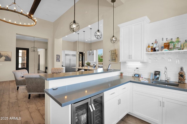 29067 N 71st Ave, Peoria, AZ 85383 - kitchen with a high ceiling, a peninsula, stainless steel built in refrigerator, beverage cooler, and hardwood / wood-style flooring