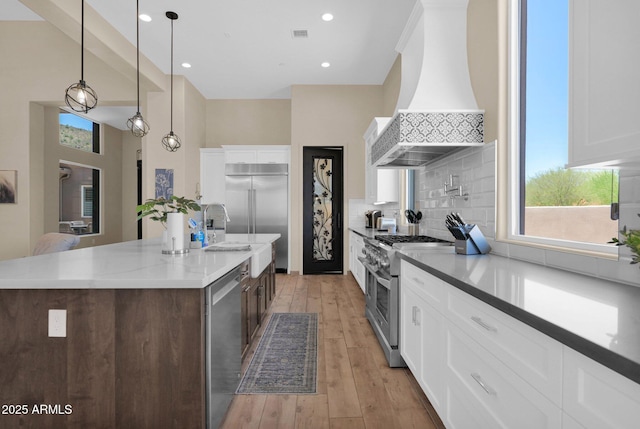 29067 N 71st Ave, Peoria, AZ 85383 - kitchen featuring high quality appliances, premium range hood, decorative backsplash, a spacious island, and healthy amount of natural light