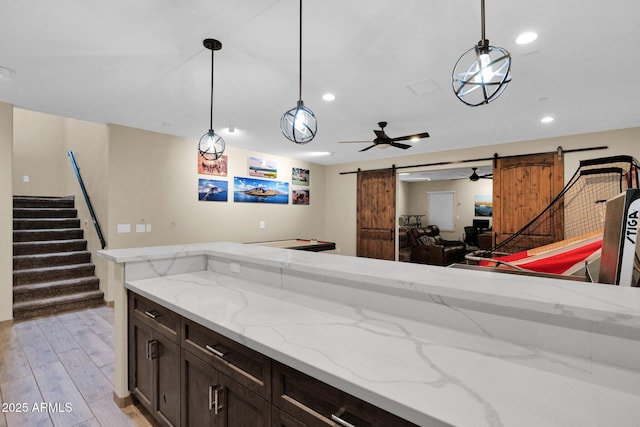 29067 N 71st Ave, Peoria, AZ 85383 - kitchen with a barn door, light wood-style flooring, decorative light fixtures, light stone counters, and recessed lighting