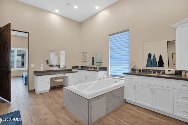 29067 N 71st Ave, Peoria, AZ 85383 - full bathroom with a high ceiling, two vanities, wood finished floors, a bath, and plenty of natural light