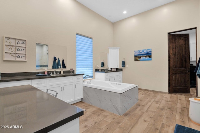 29067 N 71st Ave, Peoria, AZ 85383 - bathroom featuring a garden tub, vanity, and wood finished floors