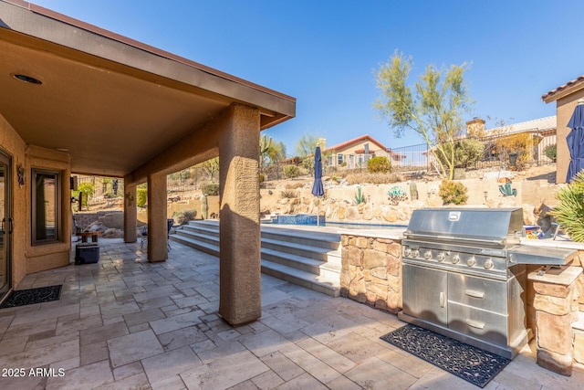 view of patio featuring exterior kitchen and a grill