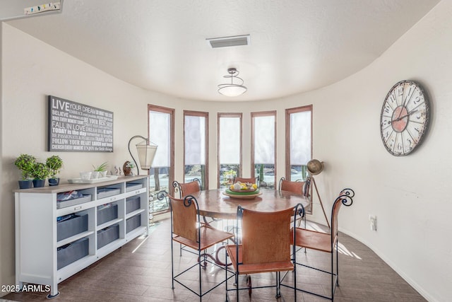 dining room featuring a textured ceiling and dark hardwood / wood-style floors