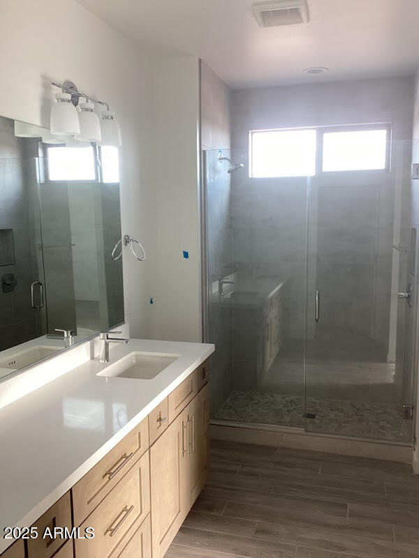 bathroom featuring vanity, hardwood / wood-style floors, and walk in shower