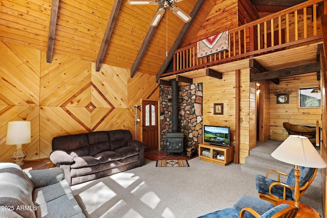 246 E Acorn Ln, Payson, AZ 85541 - carpeted living area with a wooden ceiling with exposed beams, a wood stove, wood walls, a ceiling fan, and high vaulted ceiling