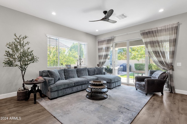 living room with ceiling fan, plenty of natural light, and wood-type flooring