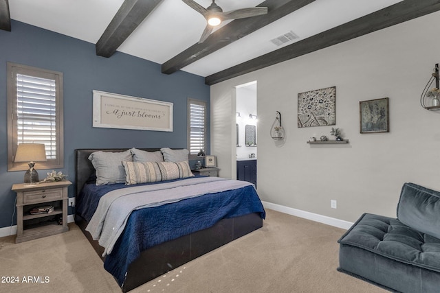 carpeted bedroom featuring ceiling fan, beam ceiling, and ensuite bath