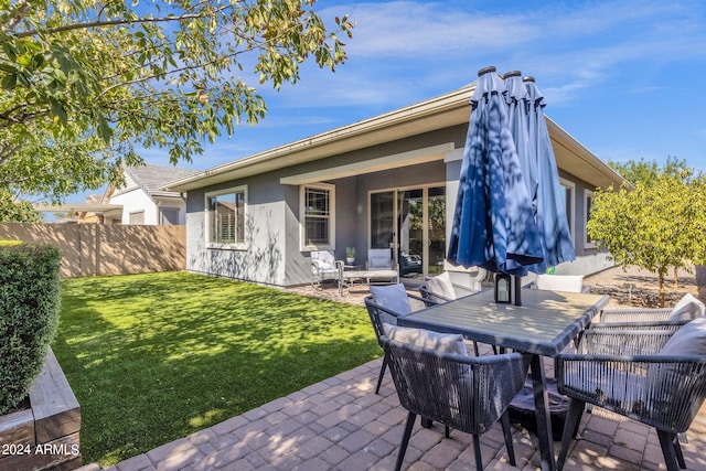 rear view of property featuring a yard and a patio