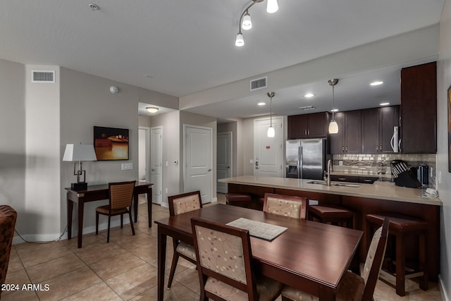 kitchen with decorative light fixtures, stainless steel appliances, sink, kitchen peninsula, and decorative backsplash