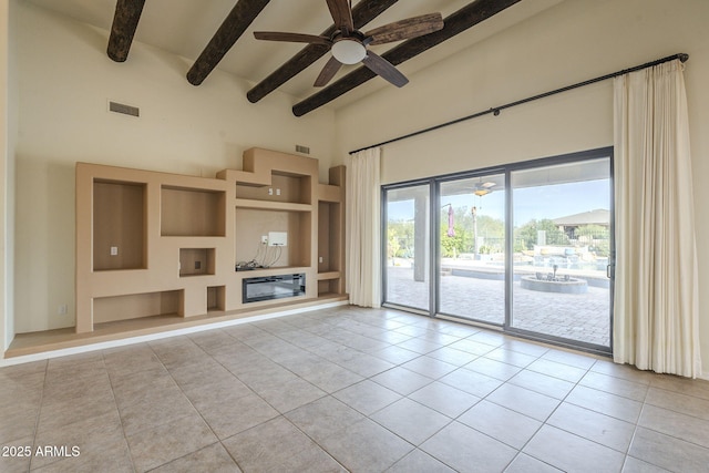 unfurnished living room with visible vents, a ceiling fan, beamed ceiling, tile patterned flooring, and a high ceiling