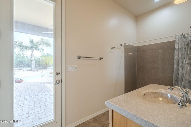 bathroom featuring baseboards, tile patterned flooring, a sink, and a shower with curtain