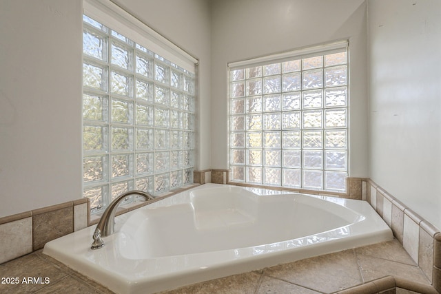 bathroom featuring plenty of natural light and a bath