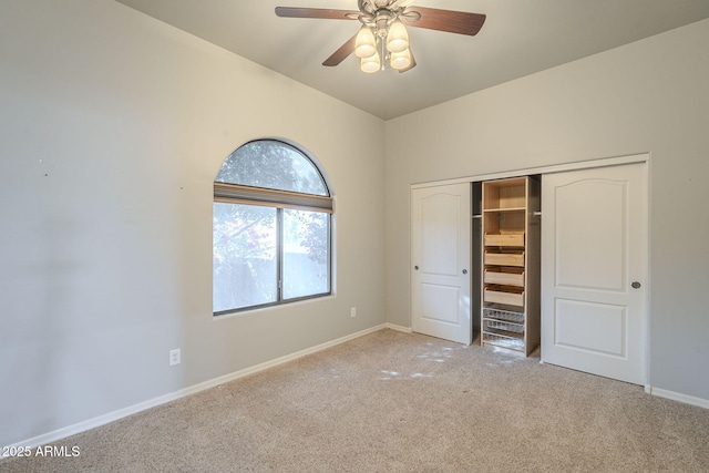 unfurnished bedroom featuring light carpet, a ceiling fan, baseboards, and a closet