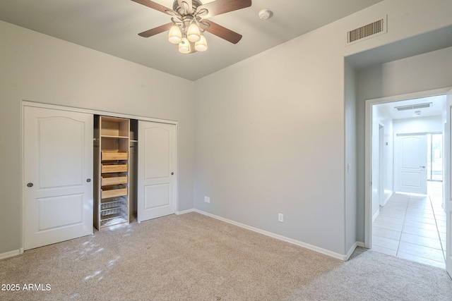 unfurnished bedroom featuring baseboards, carpet, visible vents, and a closet