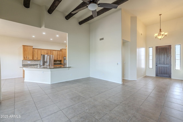 unfurnished living room with high vaulted ceiling, light tile patterned flooring, beam ceiling, and baseboards