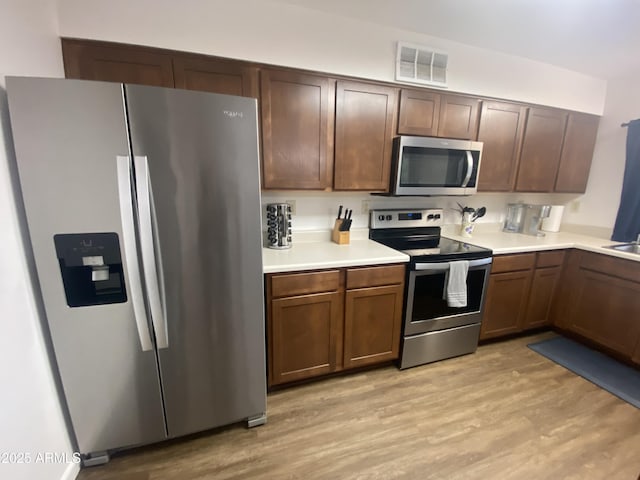 903 W Jacinto Cir, Mesa, AZ 85210 - kitchen with stainless steel appliances, light wood-style flooring, and light countertops