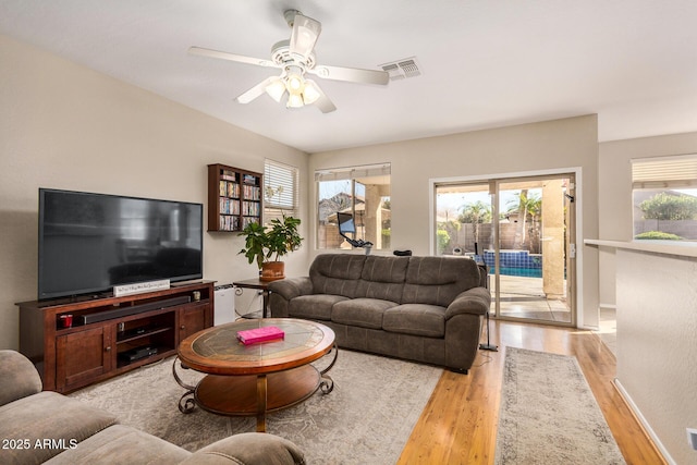 living room featuring ceiling fan and light hardwood / wood-style floors