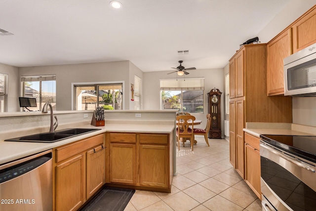 kitchen with ceiling fan, light tile patterned floors, appliances with stainless steel finishes, and sink